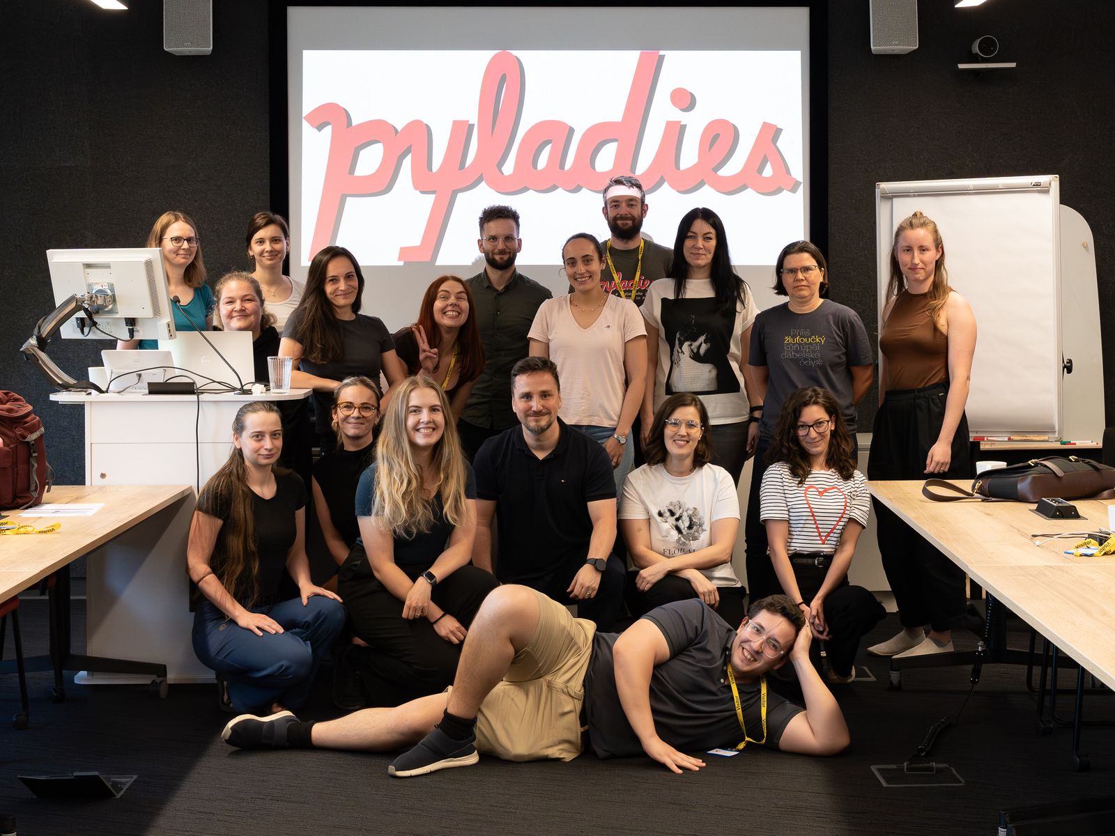 Tým koučů a účastnice kurzu před logem PyLadies na závěrečném workshopu v Barclays, červen 2026